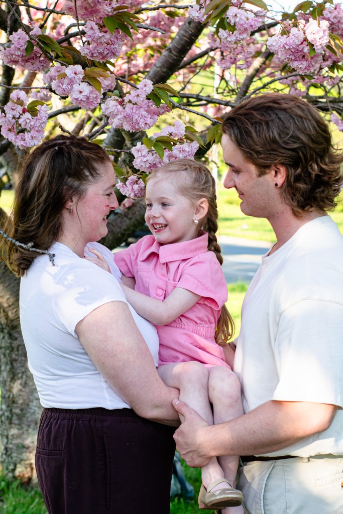 family posing under a cherry blossom tree