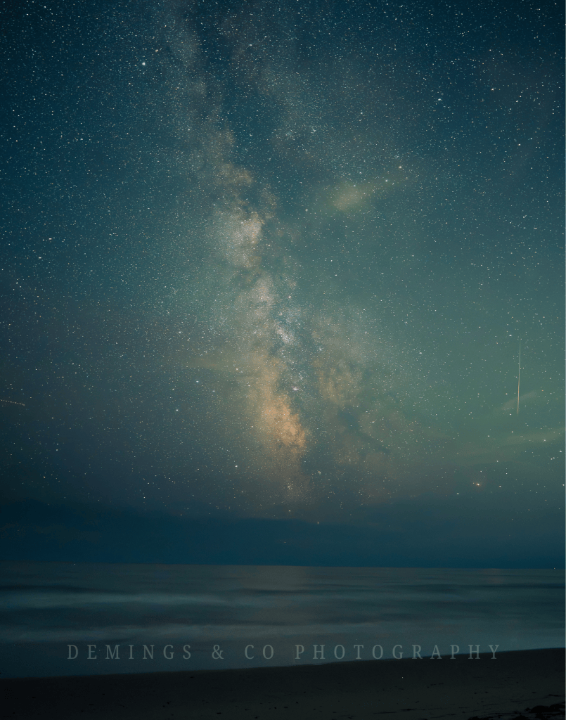A stunning view of the Milky Way galaxy shining brightly in the night sky, above a calm ocean with gentle waves, captured from a beach.